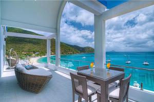 una casa con balcón con vista al mar en Cane Garden Bay Beach Hotel, en Cane Garden Bay