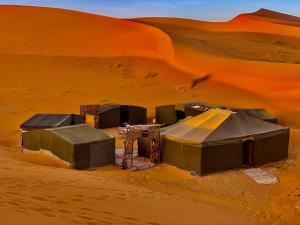 a camp in the desert with a sand dune at Merzouga Standard Camp in Merzouga