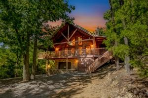 a log cabin in the woods with a wrap around deck at Sevierville Cabin with Deck Minutes to Pigeon Forge in Sevierville