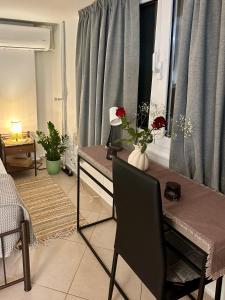 a living room with a table with flowers on it at Adrianas Central Stay in Patra