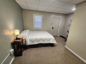 Un dormitorio con una cama y una mesa y una ventana. en Dunnstown Lodge, en Lock Haven