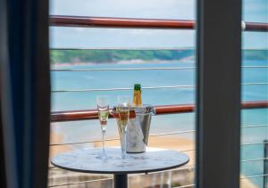 a table with two glasses and a bottle of champagne at St Brides Spa Hotel & Village Apartments in Saundersfoot