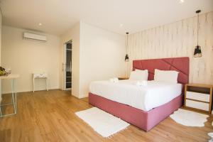 ケルースにあるYana Luxury Homeの赤いヘッドボードが付いた大きなベッドのある寝室