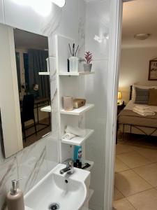 a bathroom with a sink and a mirror at Adrianas Central Stay in Patra