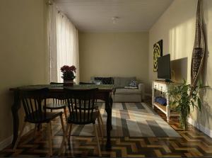 una sala de estar con una mesa, sillas y un sofá en Casa da Vila 2 dormitorios - Centro de Floripa, en Florianópolis