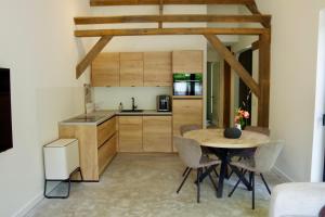a kitchen with a table and chairs in a room at In de olde kapschuur in Beemte