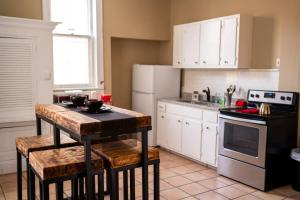 a kitchen with white cabinets and a table with stools at Historic Midtown Apartment in Memphis
