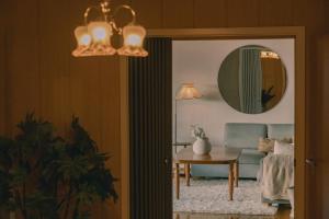 a living room with a blue couch and a mirror at Nature stay, near the city in Hjorten