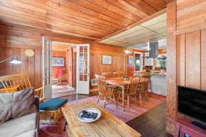 Una sala de estar con una mesa y una cocina. en Historic Oceanside Cabin with Peek-a-boo views dog friendly, en Oceanside