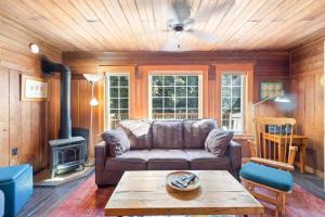 una sala de estar con un sofá y una chimenea en Historic Oceanside Cabin with Peek-a-boo views dog friendly, en Oceanside