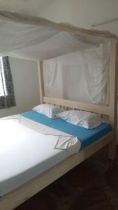 1 dormitorio con litera con sábanas y almohadas blancas en Watamu villas, en Watamu