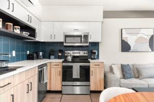 a kitchen with a stove top oven next to a couch at 2BR in Downtown with Parking in Spokane