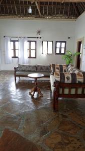 una sala de estar con un sofá y una mesa en Watamu villas, en Watamu