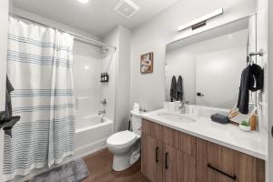 Un baño con inodoro, lavabo y ducha. en 2BR Cozy Apartment in DT, en Spokane
