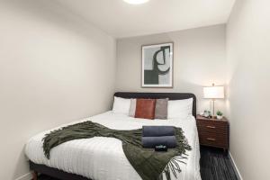 1 dormitorio con 1 cama con manta y mesita de noche en 2BR Cozy Apartment in DT, en Spokane