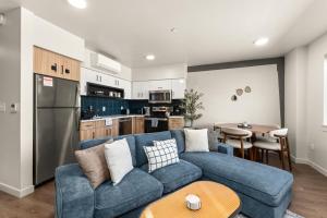Una sala de estar con un sofá azul y una cocina. en 2BR Cozy Apartment in DT, en Spokane 31 fotos más