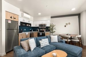 a living room with a blue couch and a kitchen at 2BR Cozy Apartment in DT in Spokane