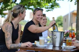 three women sitting at a table with a bottle of wine at Kanal 33 in Schafstedt