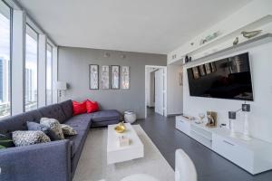 マイアミにあるStunning views - Icon Brickellの青いソファとテレビのあるリビングルーム
