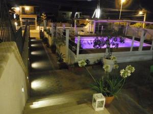 an outdoor swimming pool at night with purple lights at B&B Korsal in Noto Marina