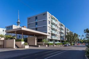 a building with a parking lot in front of it at QV Stays Viaduct Harbour Elegance in Auckland