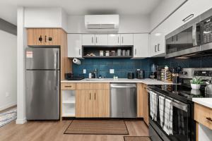 a kitchen with stainless steel appliances and wooden cabinets at DT 2br 2bath Modern Apartment in Spokane