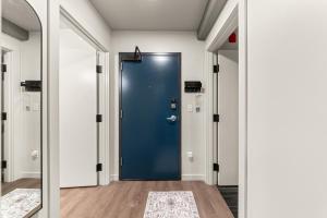 eine blaue Tür in einem Flur mit weißen Wänden in der Unterkunft Downtown Luxury Stay 2BR in Spokane