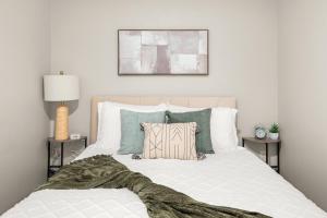 ein Schlafzimmer mit einem großen weißen Bett und Kissen in der Unterkunft Downtown Luxury Stay 2BR in Spokane