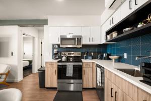 a kitchen with white cabinets and a stove top oven at DT 2br 2bath Apartment in Spokane +27 photos