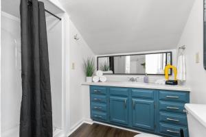 a bathroom with a blue sink and a mirror at Roomy Central Hub, Games, Fire Pit & Downtown Fun in Oshkosh +50 photos