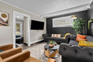 a living room with couches and a flat screen tv at Roomy Central Hub, Games, Fire Pit & Downtown Fun in Oshkosh