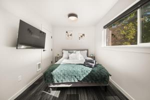 a bedroom with a bed and a flat screen tv at DT 2br 2bath Apartment in Spokane