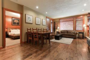 a living room with a dining room table and a bedroom at Slalom Creek 2 Bedroom & Den in Rossland