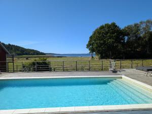 FjäråsにあるSmedsgård Farm Stayの柵前のスイミングプール