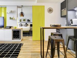 uma cozinha e sala de estar com uma mesa e bancos em Novotel Paris Centre Bercy em Paris mais 108 fotografias