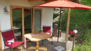 Un patio con una mesa y una sombrilla roja. en Mountain Lodge, en Lenggries 16 fotos más