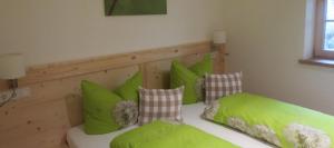 een kamer met 2 bedden en groene kussens bij Mountain Lodge in Lenggries