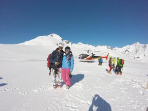 a group of people standing in the snow next to a helicopter at Arpege Des Neiges in Sainte-Foy-Tarentaise