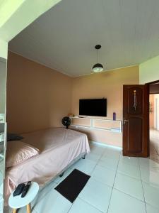 a bedroom with a bed and a flat screen tv at Quartos privativos e casa compartilhada no centro de Belém in Belém