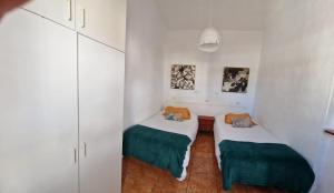 two beds in a room with white walls at Viviendas Casa Abuela in El Paso