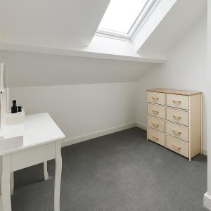 an attic room with a white desk and a skylight at LT Duplex - 1 Bedroom Apartment in Leicester