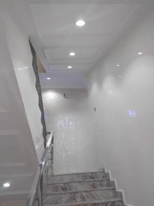 Una escalera en un edificio con una pared blanca. en Villa Engracia Suite, en Kaduna