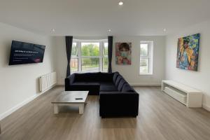 a living room with a black couch and a table at LT Duplex - 1 Bedroom Apartment in Leicester