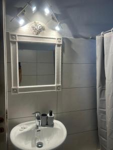 a bathroom with a sink and a mirror at The Spring House in Tiros