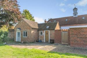 an old brick house with a clock tower on top at 1 Bed in Wellesbourne oc-w33028 in Charlecote