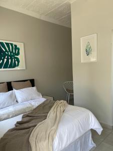 a bedroom with two beds and a chair at Lani Accommodation in Pretoria