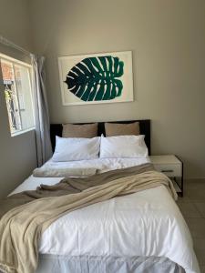a bedroom with a large bed with white sheets at Lani Accommodation in Pretoria