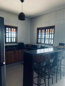 una cocina con encimera negra y sillas de bar en Sítio Lopes, en Toledo