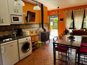 a kitchen and living room with a table and a stove at Apartamentos rurales FlordeLinto in La Cárcoba