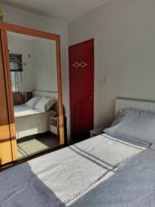 1 dormitorio con espejo junto a la cama en Loft do Bosque, en Ananindeua